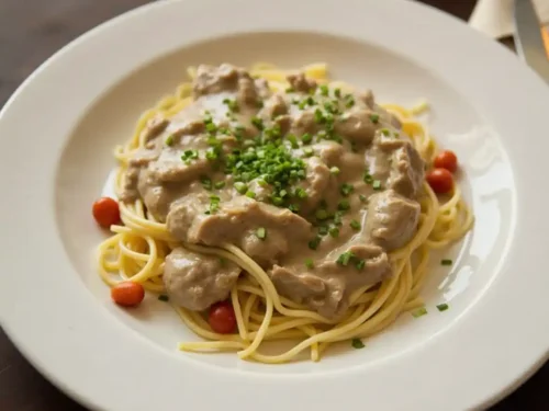 A creamy and savory beef stroganoff served with tender beef strips, mushrooms, and pasta in a rich sauce.