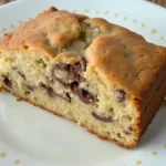 Moist banana chocolate chip cake topped with melted chocolate chips, perfect for dessert or a sweet snack.